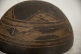 Hand-carved geometric patterns and aged texture on the dark vintage African wood bowl.