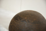 Carved geometric motifs and aged texture on the dark wood of a vintage African bowl.