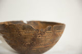Hand-carved geometric patterns, deep cracks, and metal repairs on a vintage African bowl.