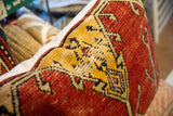 Hand-knotted red and gold Oushak pattern on the vintage rug fragment pillow.
