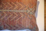 Hand-knotted texture of the vintage pillow with rust, pale green, and beige geometric pattern.