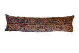 Collector's antique 1910s Kerman fragment lumbar pillow with muted red and blue patterns.