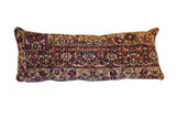 Antique Kerman rug fragment lumbar pillow with rich ruby, sapphire, and beige floral pattern.