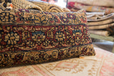Intricate deep red, navy, and gold stylized pattern on the vintage Kerman rug fragment pillow.
