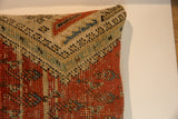 Antique Mir Serbend rug fragment pillow corner, featuring geometric pattern in muted red, beige, and blue.