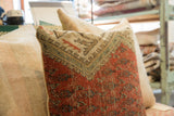 Close-up of the vintage rug fragment pillow's hand-knotted pile and faded geometric motifs.