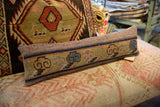Detail of the Khotan rug fragment pillow, displaying pastel cloud motifs and hand-knotted texture.