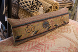 Close-up of handmade antique Khotan rug fragment lumbar pillow, featuring geometric motifs and time-softened tones.