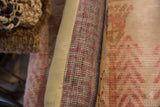 Vintage Khotan rug fragment pillow: hand-knotted muted pink and grey pile, beige edge.