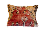Mid-20th century Turkish Oushak rug fragment pillow, faded geometric rust red and beige pattern.