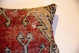 Detail of hand-knotted vintage Oushak fragment pillow with rust red and beige geometric design.