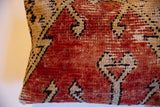 Close-up of the vintage Oushak rug pillow showing its hand-knotted pile and terracotta geometric motifs.