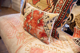 Distressed red and cream hand-knotted Oushak rug fragment pillow texture.