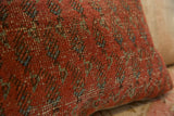 Antique Mir Serbend rug fragment pillow, textured terracotta pile with faded blue and brown motifs.