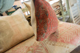 Textured red-orange and blue pile on antique Mir Serbend rug fragment pillow side.
