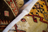 Gold, red, black geometric pattern on a hand-knotted Oushak rug fragment pillow, light woven side.