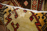 Hand-knotted pile and woven edge of the Oushak rug fragment pillow, with red, black, and tan geometric motifs.