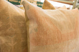 Hand-knotted Oushak rug fragment pillow in time-softened beige and subtle peach hues.
