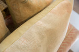 Hand-knotted beige pile texture meeting cream fabric side of the vintage pillow.