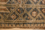 Hand-knotted pile of vintage rug fragment pillow, showing muted greens, blues, and sandy beige with visible foundation.