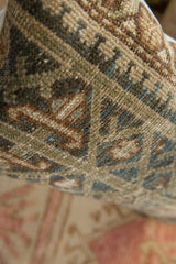 Vintage hand-knotted Persian rug fragment pile with geometric design in muted earth tones.