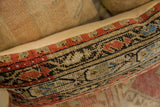 Side of antique Mir Serbend rug fragment pillow, showcasing red, blue, and black geometric pattern.