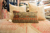 Antique circa 1910s Mir Serbend rug fragment pillow, geometric patterns in terracotta and blue.