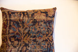 Worn texture of the antique Kerman rug fragment pillow, with faded navy, maroon, and tan pattern.