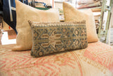 Textured hand-knotted vintage lumbar pillow featuring geometric designs in soft blue, green, and brown.