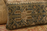 Vintage rug fragment pillow, showing its hand-knotted texture and muted earth tone pattern.