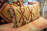 Vintage Turkish Oushak rug fragment pillow side, showing faded red geometric motifs and patterned border.