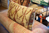Hand-knotted vintage Turkish Oushak rug fragment pillow, beige with red geometric design.