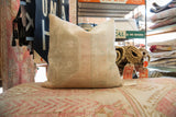 Vintage rug fragment pillow with muted beige and subtle blush hand-knotted pile.