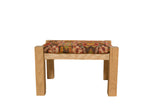 A reclaimed oak footstool topped with the textured reverse of a colorful antique Karabagh rug fragment.