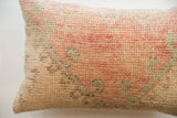Coarse hand-woven texture on the vintage rug pillow side, with faded pink, sage, and beige tones.