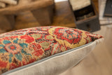 Hand-knotted pile with vibrant red, blue, and gold geometric pattern on pillow.