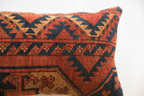 Vintage rug fragment pillow, rust, blue, gold geometric pattern, tactile texture.