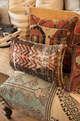 A styled collection of vintage rug fragment pillows with rustic geometric patterns and colors.
