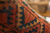 Terracotta, navy, ochre geometric pattern on hand-knotted vintage rug fragment pillow.