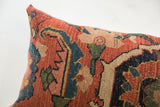 Vibrant hand-knotted Bijar pattern on antique pillow, showing rust, teal, and beige details.