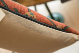 Textured antique Bijar rug fragment pillow, rust and green pattern, beige backing detail.