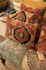 Side of an antique Bijar pillow, showing robust weave with coral, blue, and tan geometric motifs.