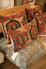 Antique Bijar rug fragment pillow displaying its robust red, navy, and beige geometric-floral pattern.