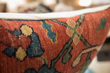 Textured surface of the antique Bijar rug pillow, featuring rust, teal, and green motifs.