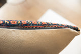 Edge of antique Bijar rug pillow, showing patterned pile, black zipper, and woven beige fabric.