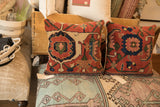 Deep ruby red and sapphire blue motifs on the hand-knotted antique Bijar fragment pillow.