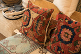 Rich ruby red, sapphire blue, and beige patterns on an antique Bijar fragment pillow.