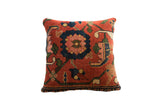 Antique Bijar rug fragment pillow featuring a terracotta field, navy, and pink floral designs.