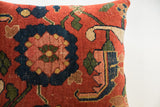 Antique Bijar rug fragment pillow displaying stylized navy blue, rust, and green floral motif.
