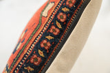 Detail of antique Persian Bijar pillow, rich floral motifs, deep blue border, beige backing.